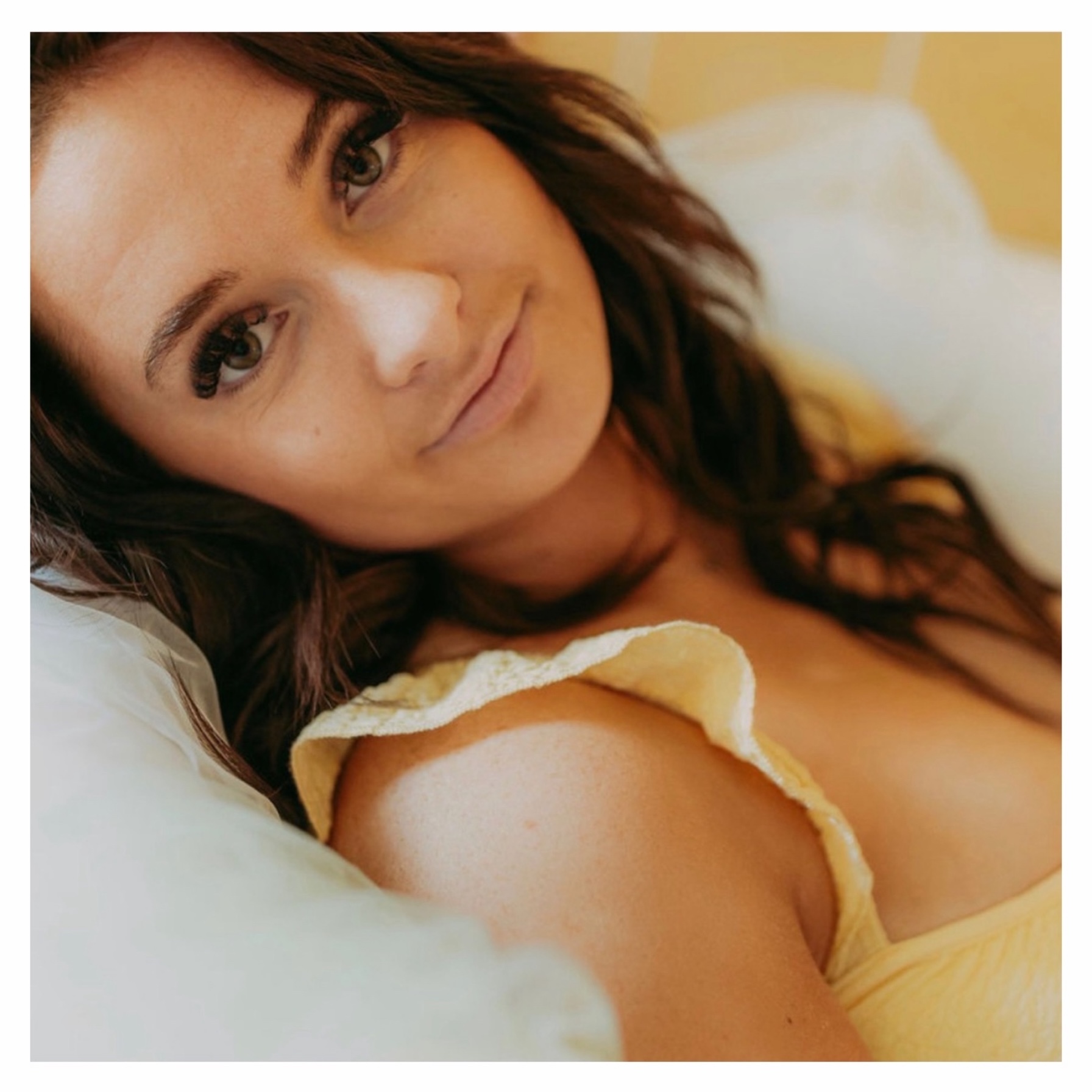 brown haired woman leaning on a pillow