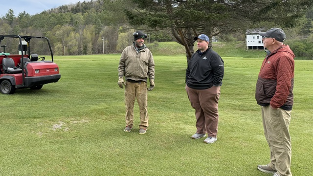 three men standing in a fairway