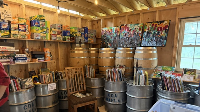 inside sap shack including 55 gallon maple syrup drums and paintings and books