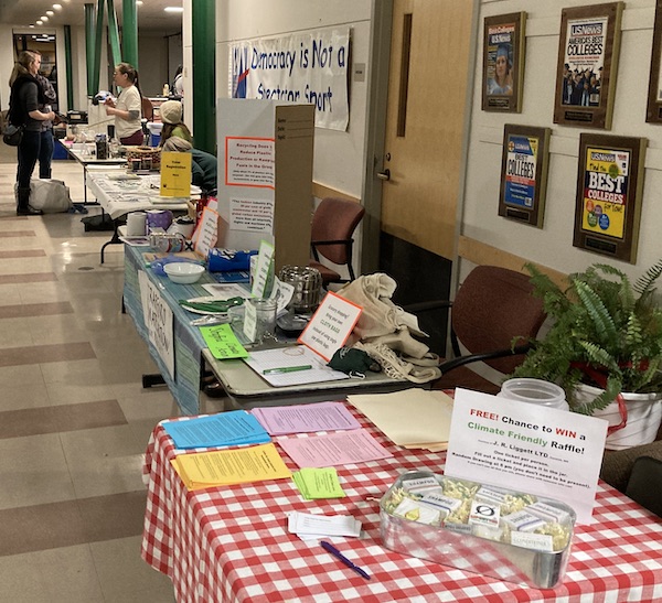 An aisle with information tables which would give people information about climate friendly things they can do and also a voter registration table