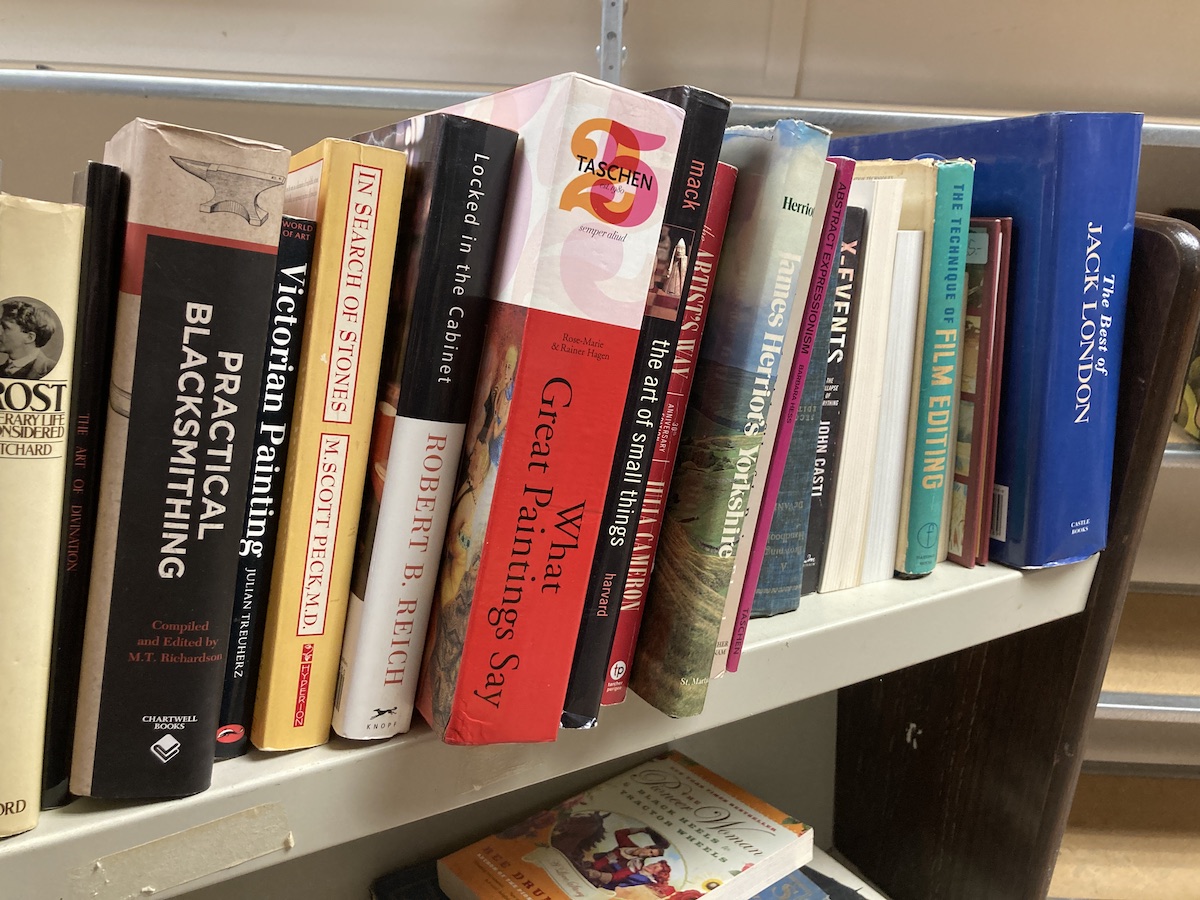 a collection of books on a white book cart