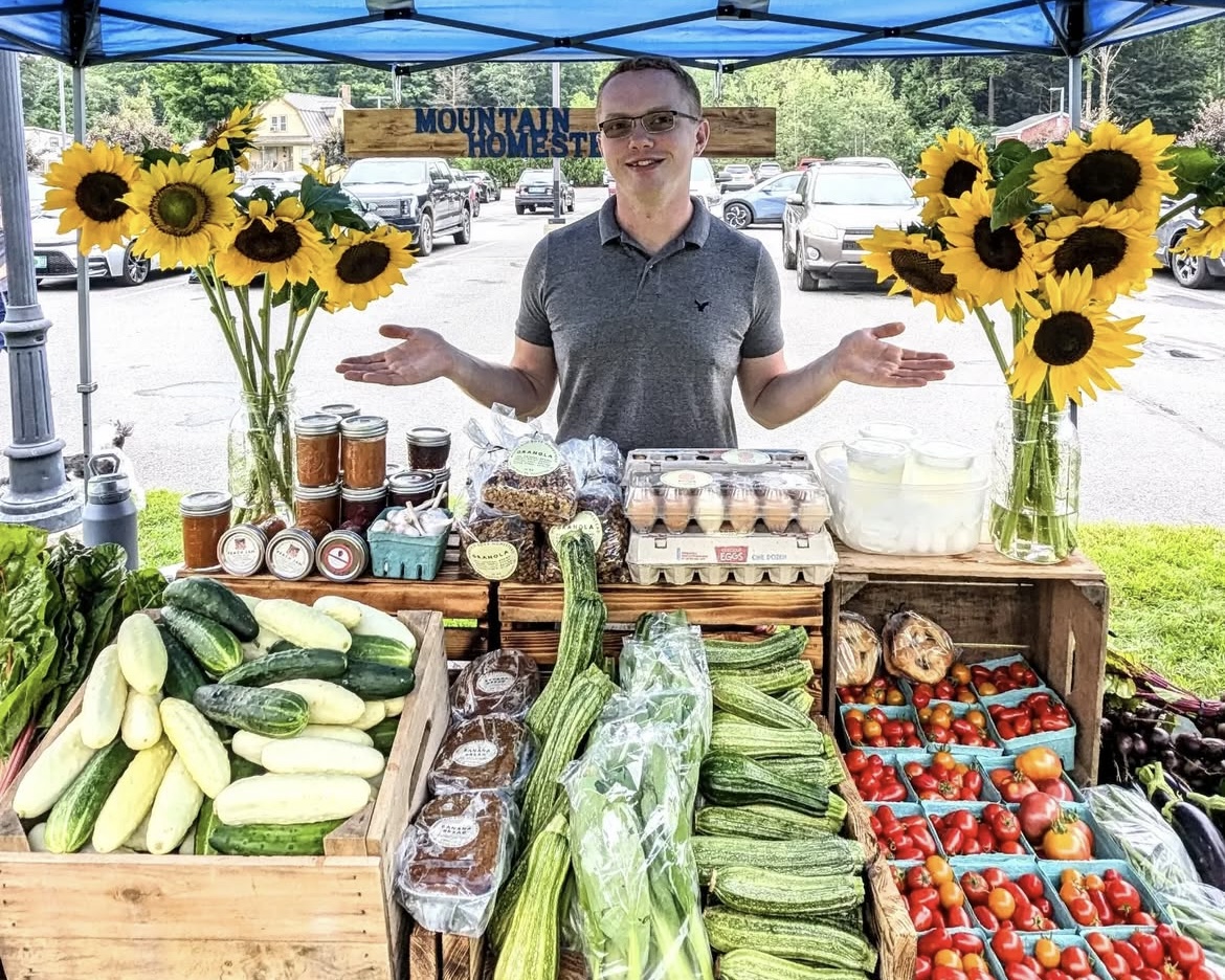 Joe at the farmers market w sunflowers and produce