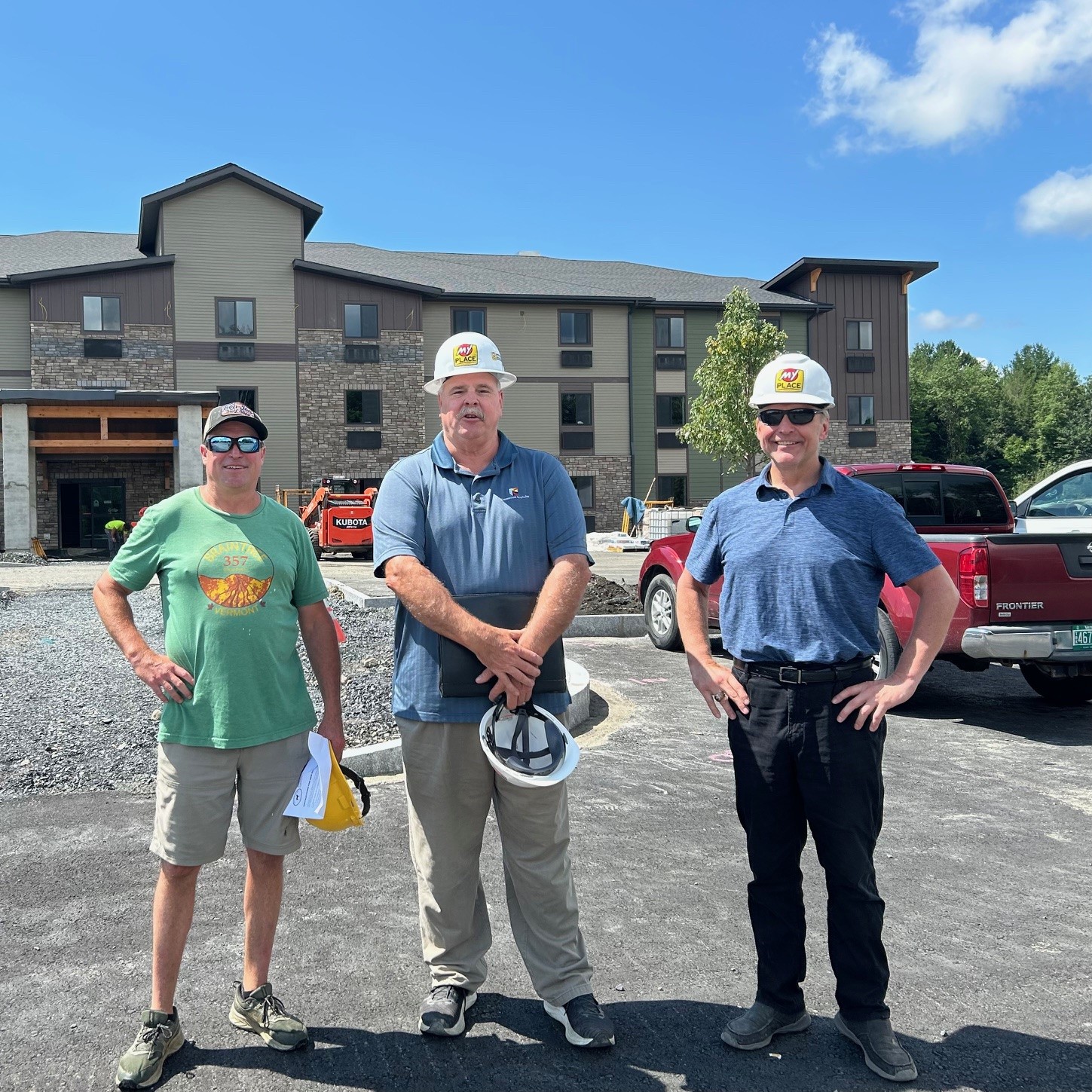 three men in front of a hotel under construction