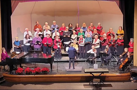 Large group of singers on a well lit stage