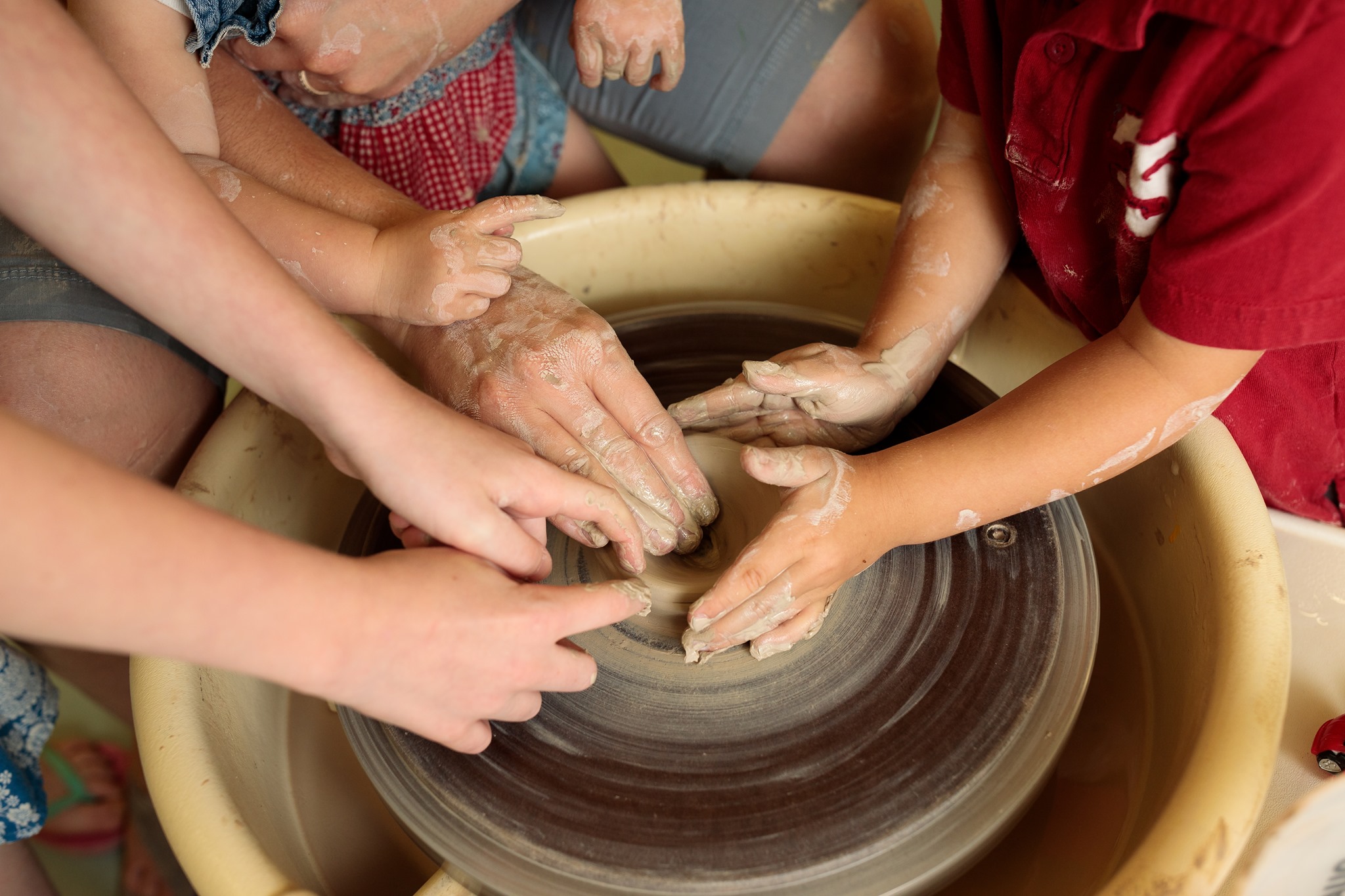 children's hands on a pottery wheel