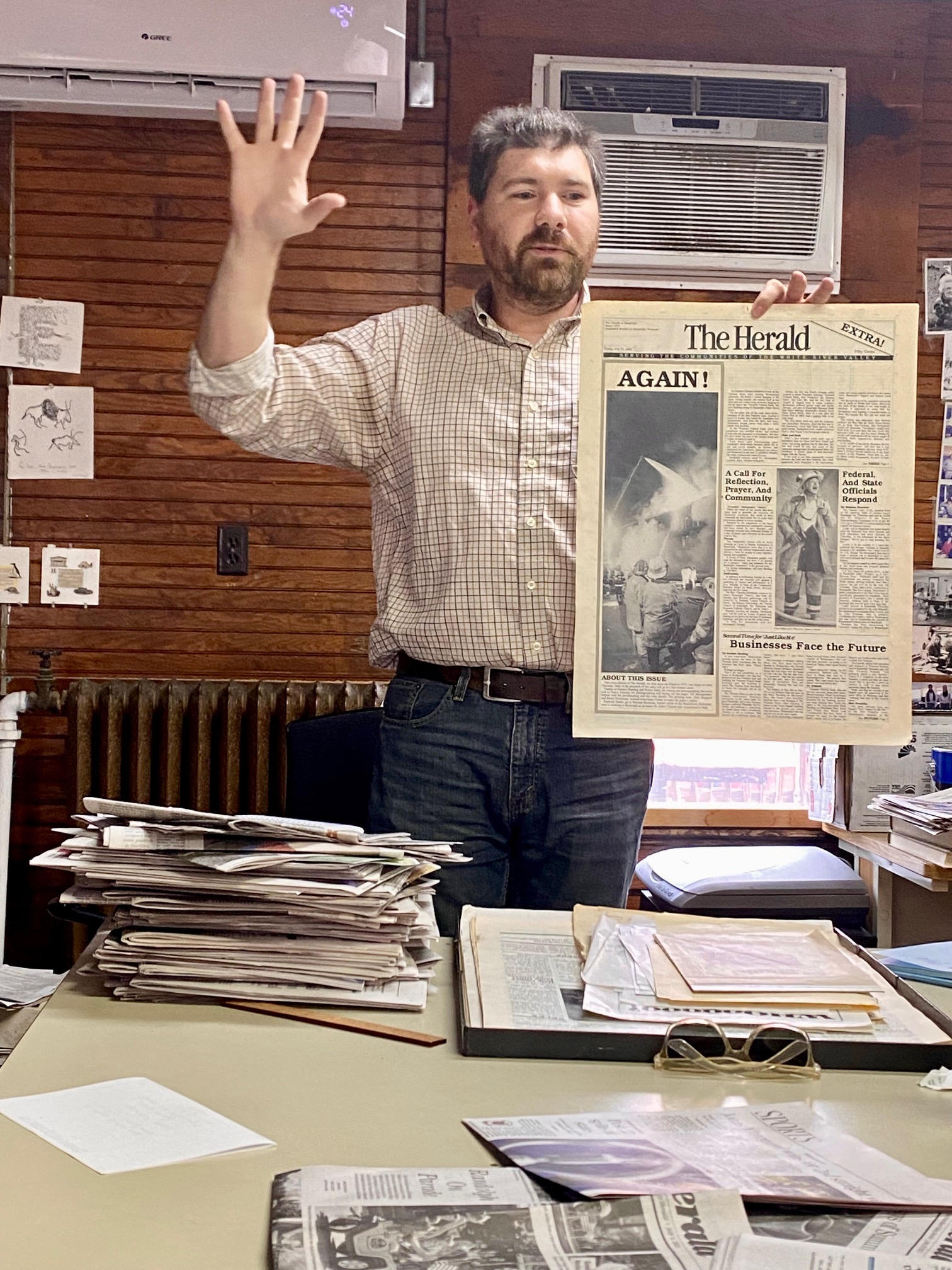 Tim in the Herald shop, holding a copy of the paper