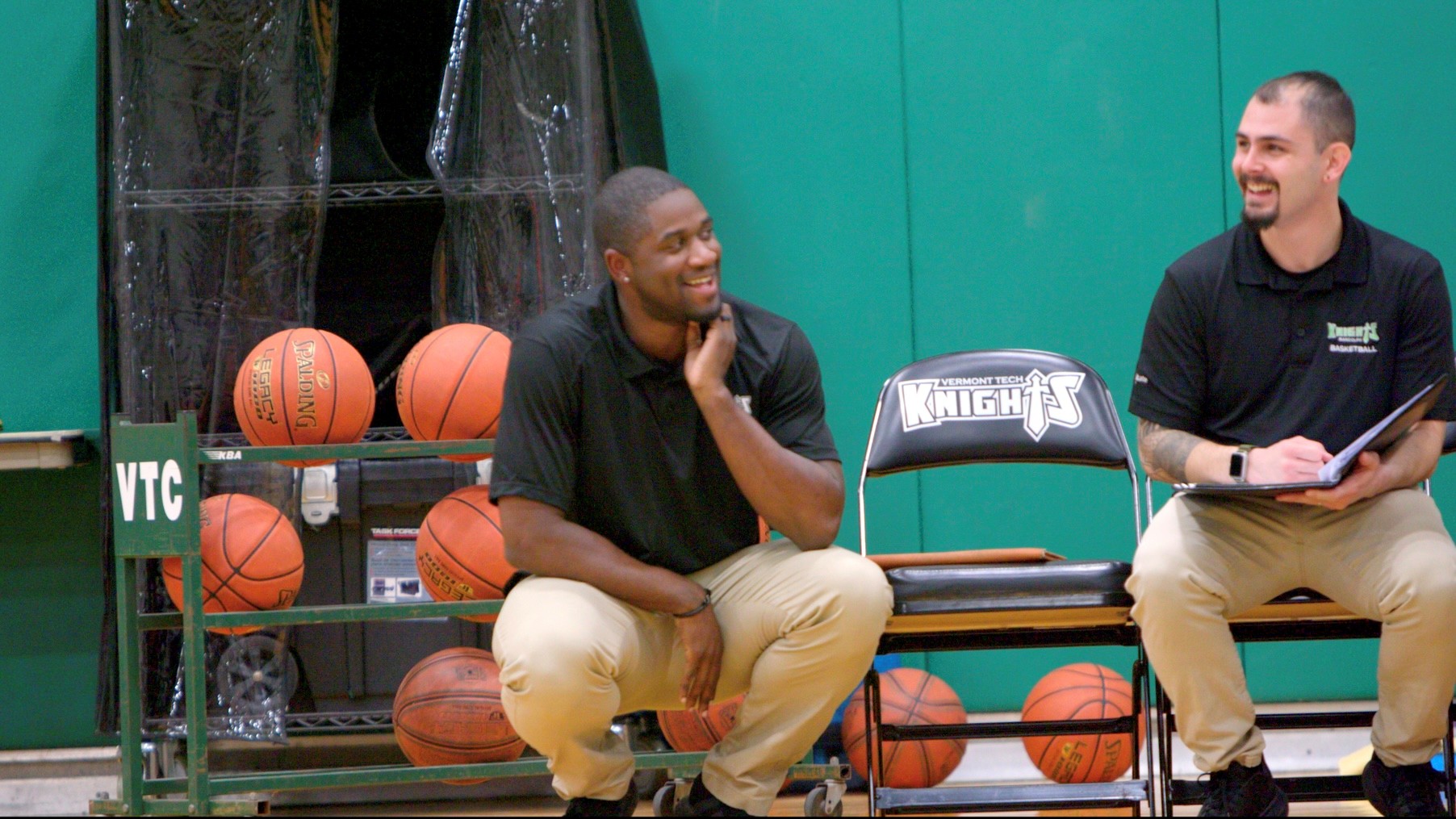 man smiling while coaching a basketball game 