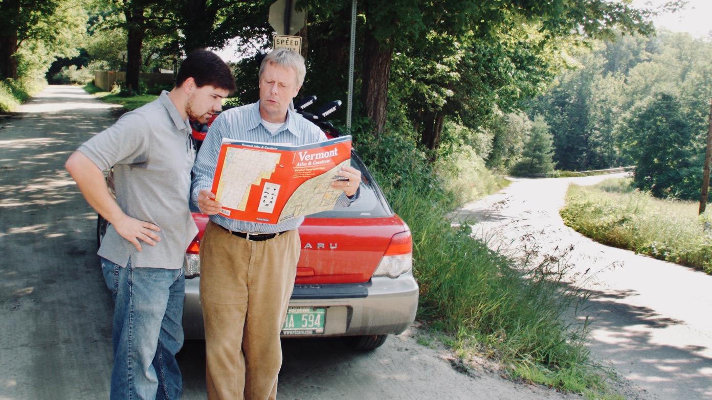 Tim and Bob in front of a car, reading a map together